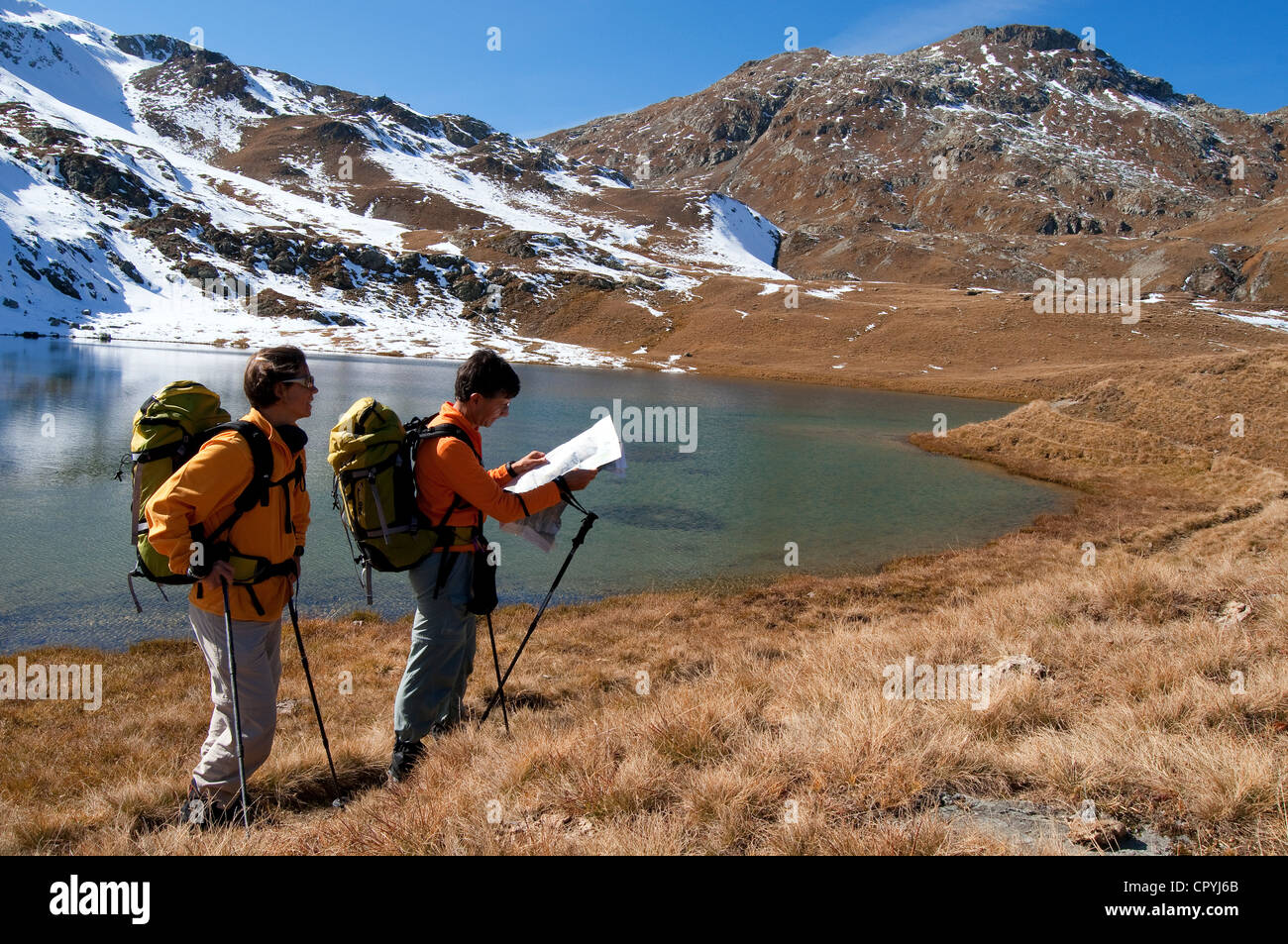La Svizzera centrale delle Alpi della Val Bregaglia Cantone dei Grigioni gli escursionisti guardando su una mappa sul bordo di un lago sotto Septimer Pass Foto Stock