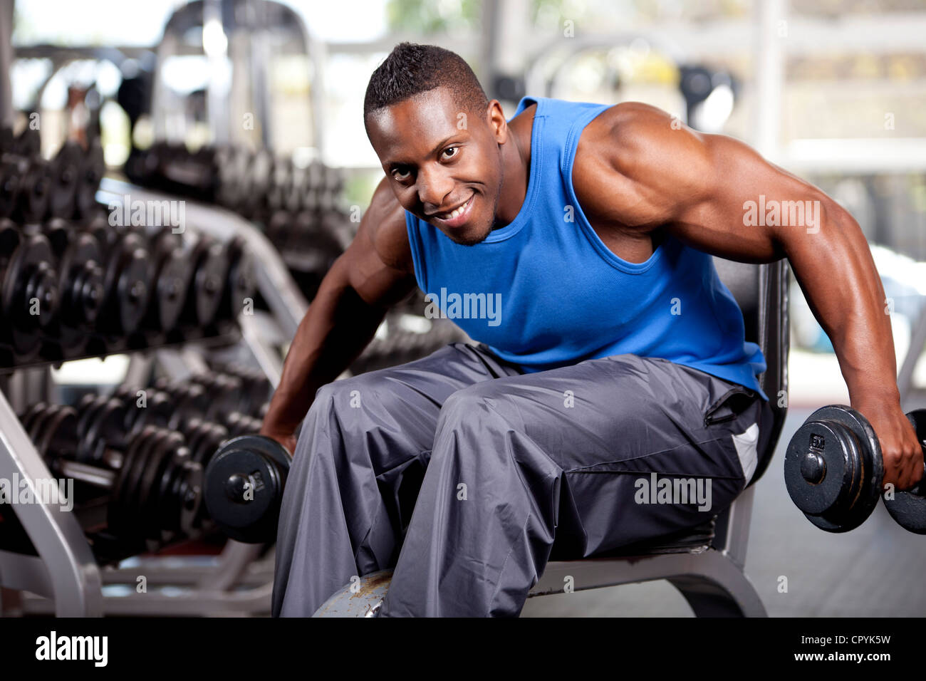 Muscolare giovane uomo nero sollevamento pesi nella palestra Foto Stock