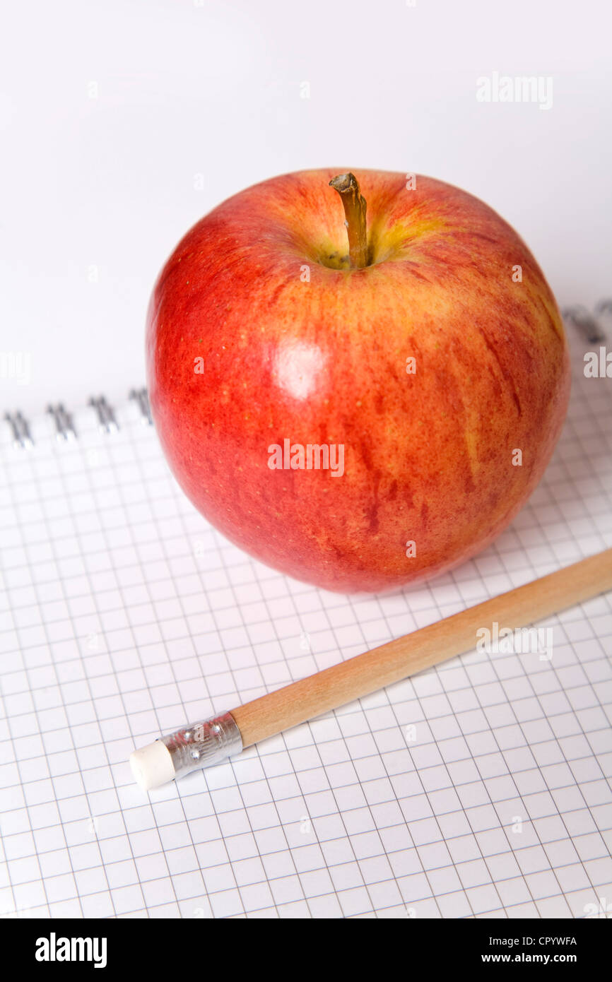 Apple e una matita su un blocco note Foto Stock
