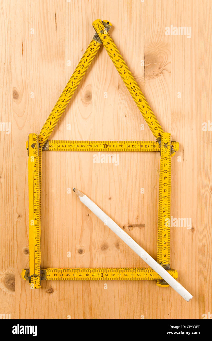 La piegatura del falegname righello piegato nella forma di una casa accanto a una matita Foto Stock