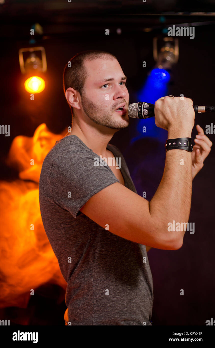 Cantante con microfono in mano Foto Stock