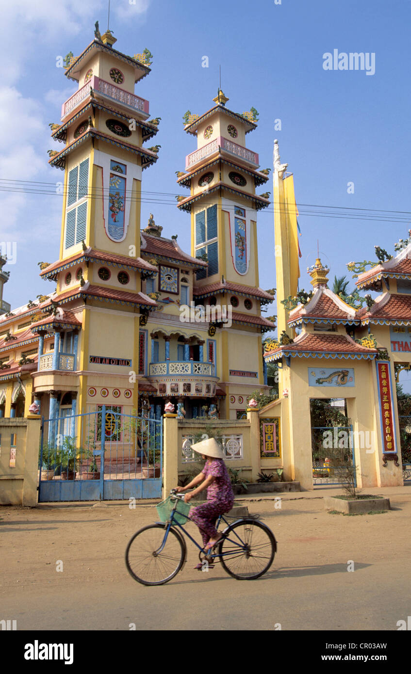 Il Vietnam, My Tho, un ciclista che passa di fronte al Cao dai Temple Foto Stock
