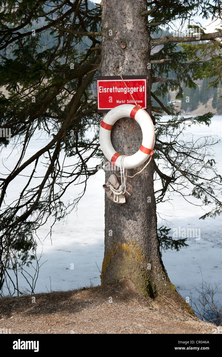 Life Saver per rompere attraverso il ghiaccio appeso a un albero, banca del lago ghiacciato Spitzingsee, Alpi Bavaresi, Alta Baviera Foto Stock