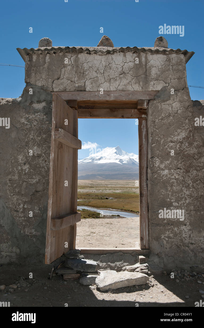 Vista attraverso un cancello aperto sulle cime innevate del Mt. Benchen Kang, 7281 m, nel Tibet centrale, U-Tsang, Himalaya Foto Stock