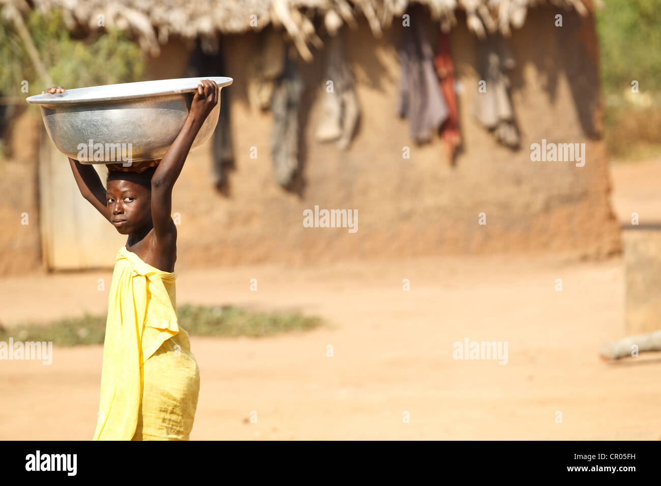 Una ragazza che non andare a scuola capi per il recupero di acqua nel villaggio di Djorbana, regione di Zanzan, Costa d'Avorio Foto Stock