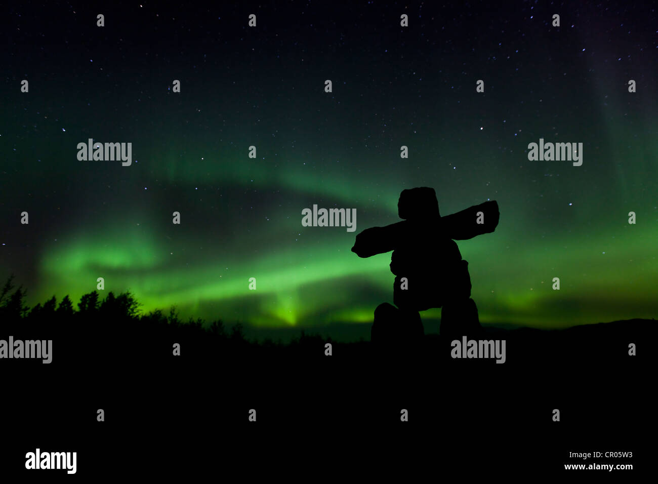Silhouette di Inuit uomo di pietra, inukshuk, inuksuk, pietra landmark o cairn Northern Lights, polari o aurora Aurora Boreale Foto Stock