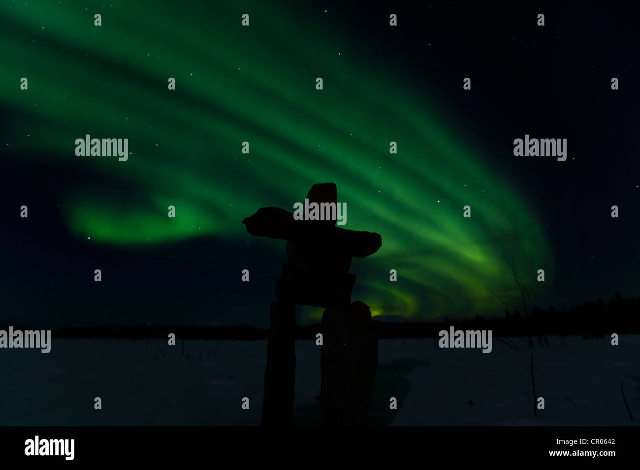 Silhouette di Inuit uomo di pietra, inukshuk oder inuksuk, pietra landmark o cairn, polare settentrionale luci, Aurora boreale, verde Foto Stock