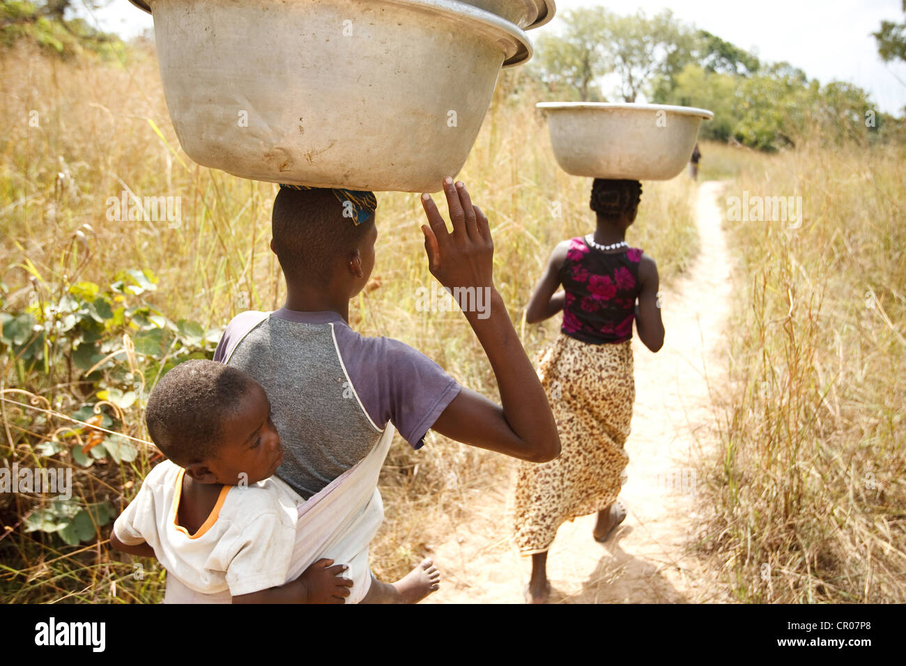 Kambou Koheva, 21 (sinistra) e Kambou Tangba, 17, a piedi lungo un percorso come loro capo al campo di lavoro nel villaggio di Kirkpadouo Foto Stock
