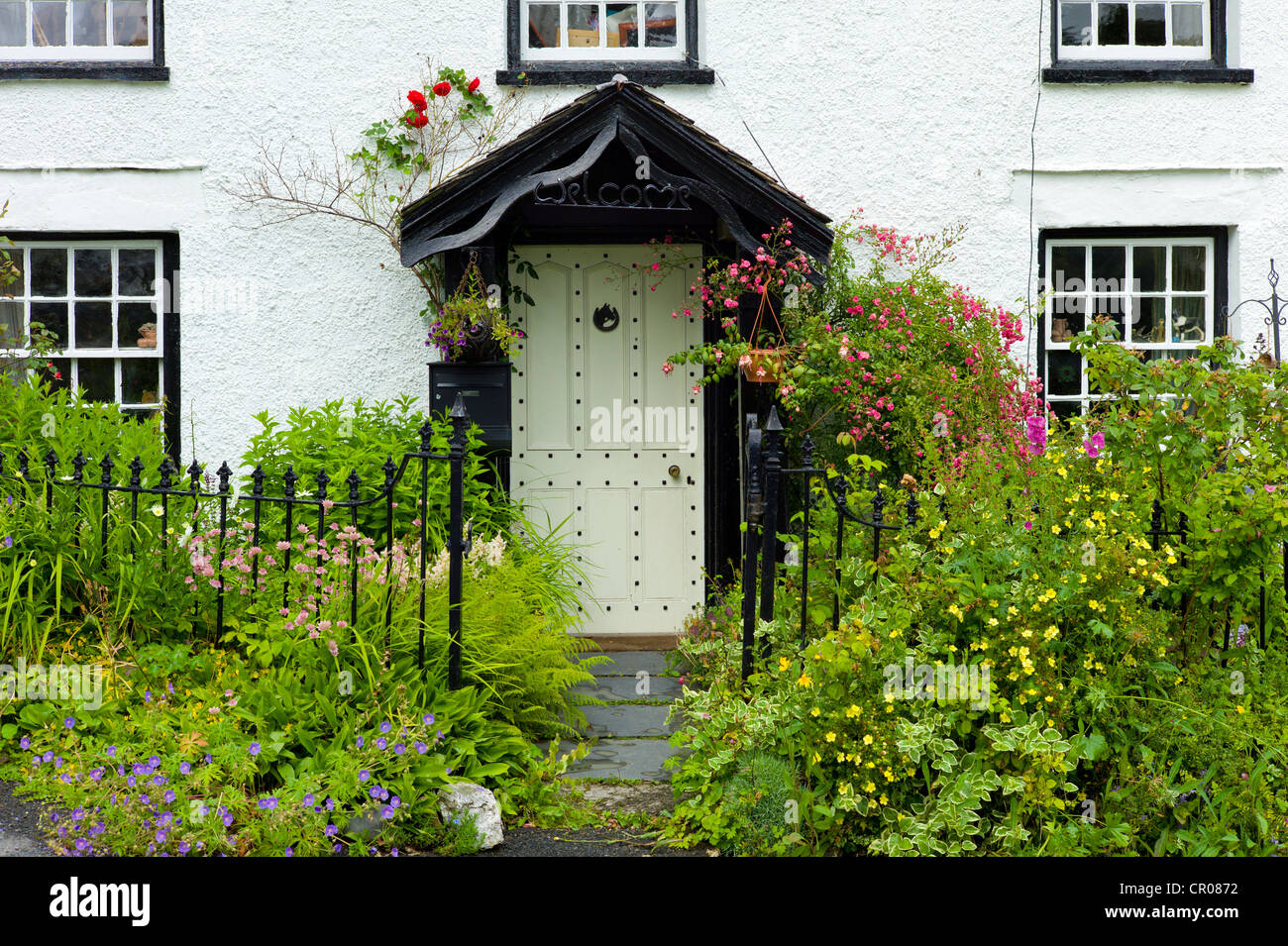 Regione dei laghi pittoreschi cottage, costellato di sportello anteriore e segno di benvenuto, a Troutbeck nel Parco Nazionale del Distretto dei Laghi, Cumbria, Regno Unito Foto Stock