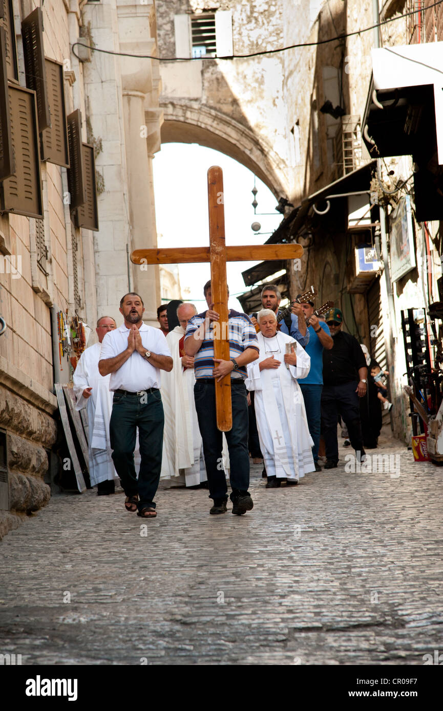 Una processione di pellegrini cattolici a piedi la Via Dolorosa, il percorso tradizionale che Gesù ha preso la sua crocifissione. Foto Stock