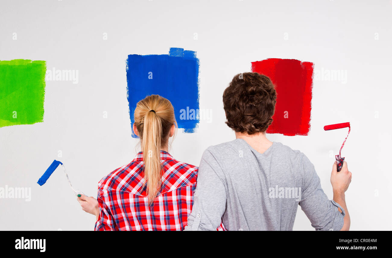 Coppia giovane di campionamento parete di vari colori di vernice Foto Stock