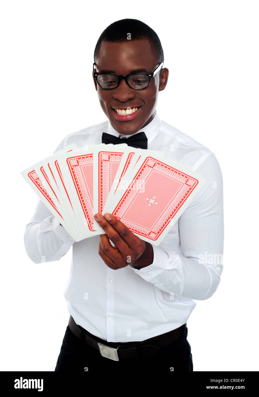 Un giovane uomo nero holding e guardando fuori mazzo di carte su sfondo bianco Foto Stock