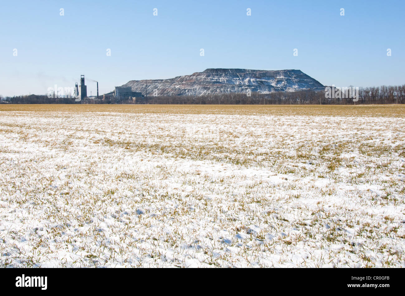 Fibre artificiali in roccia nei pressi di miniera di carbone in Ucraina con campo invernale in primo piano Foto Stock