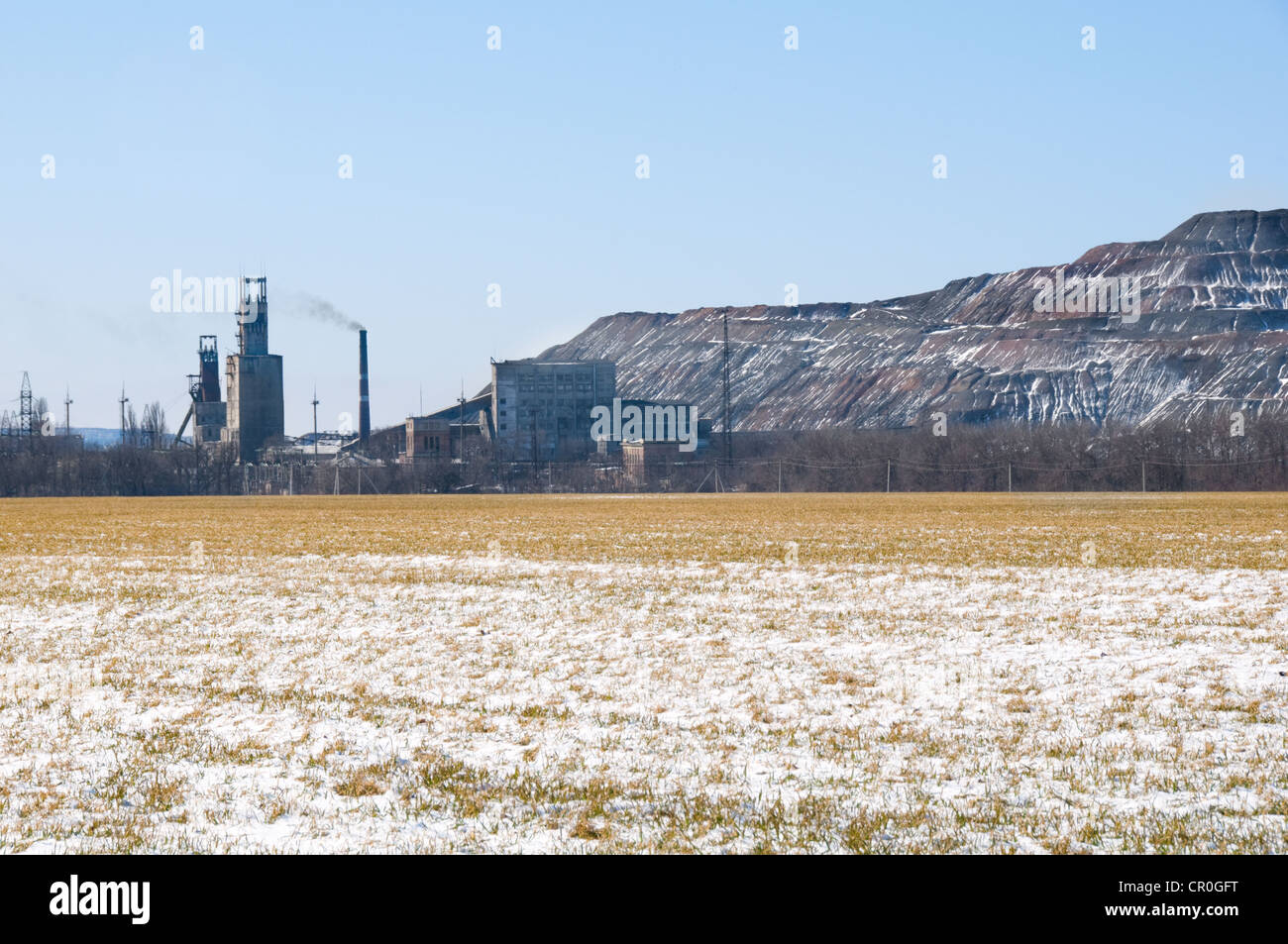 Fibre artificiali in roccia nei pressi di miniera di carbone in Ucraina con campo invernale in primo piano Foto Stock