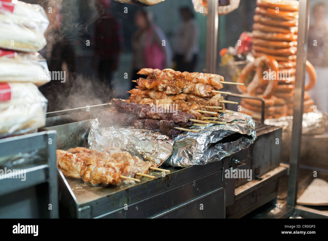Un fornitore di prodotti alimentari carrello serve grigliate di shish kebab di notte nella città di New York. Foto Stock