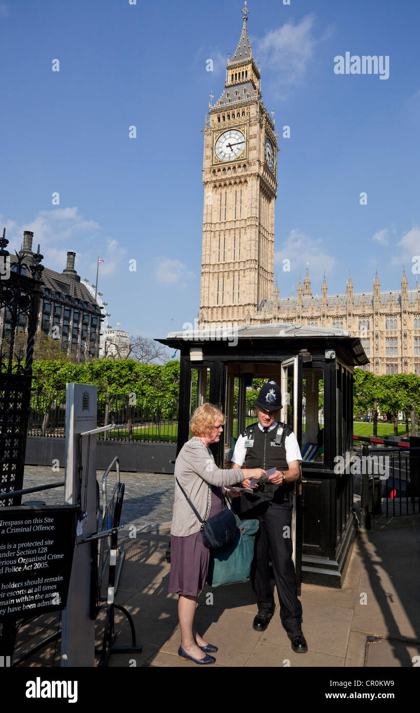 Un poliziotto fornisce informazioni ad un turista femminile, il Parlamento, il London, England, Regno Unito Foto Stock