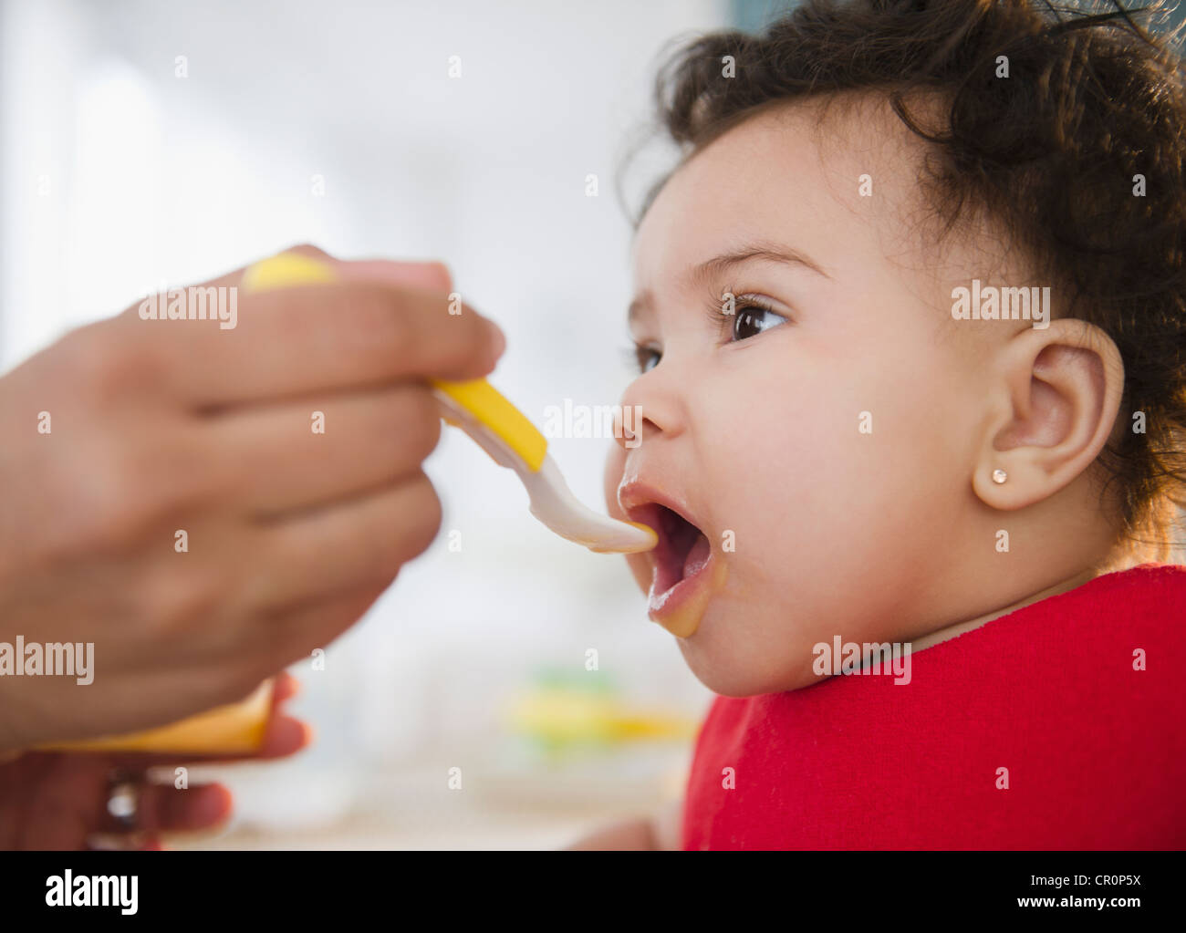 Razza mista madre del bambino di alimentazione Foto Stock