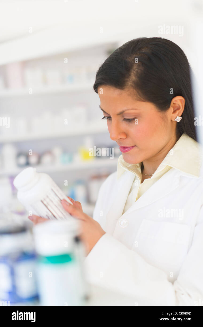 Stati Uniti d'America, New Jersey, Jersey City, il farmacista la lettura di etichetta sulla bottiglia di medicina Foto Stock