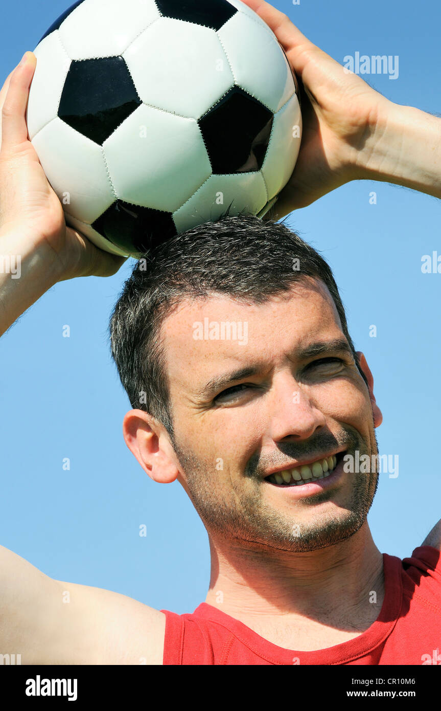 Attraente giocatore di football di bianco e nero con palloncino Foto Stock