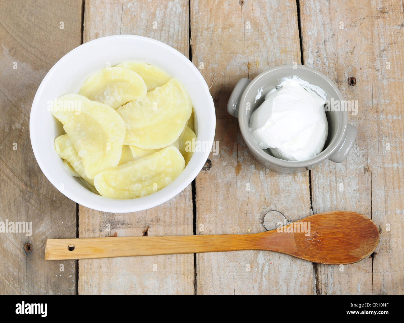 Tradizionale piatto russo pelmeni e panna acida Foto Stock