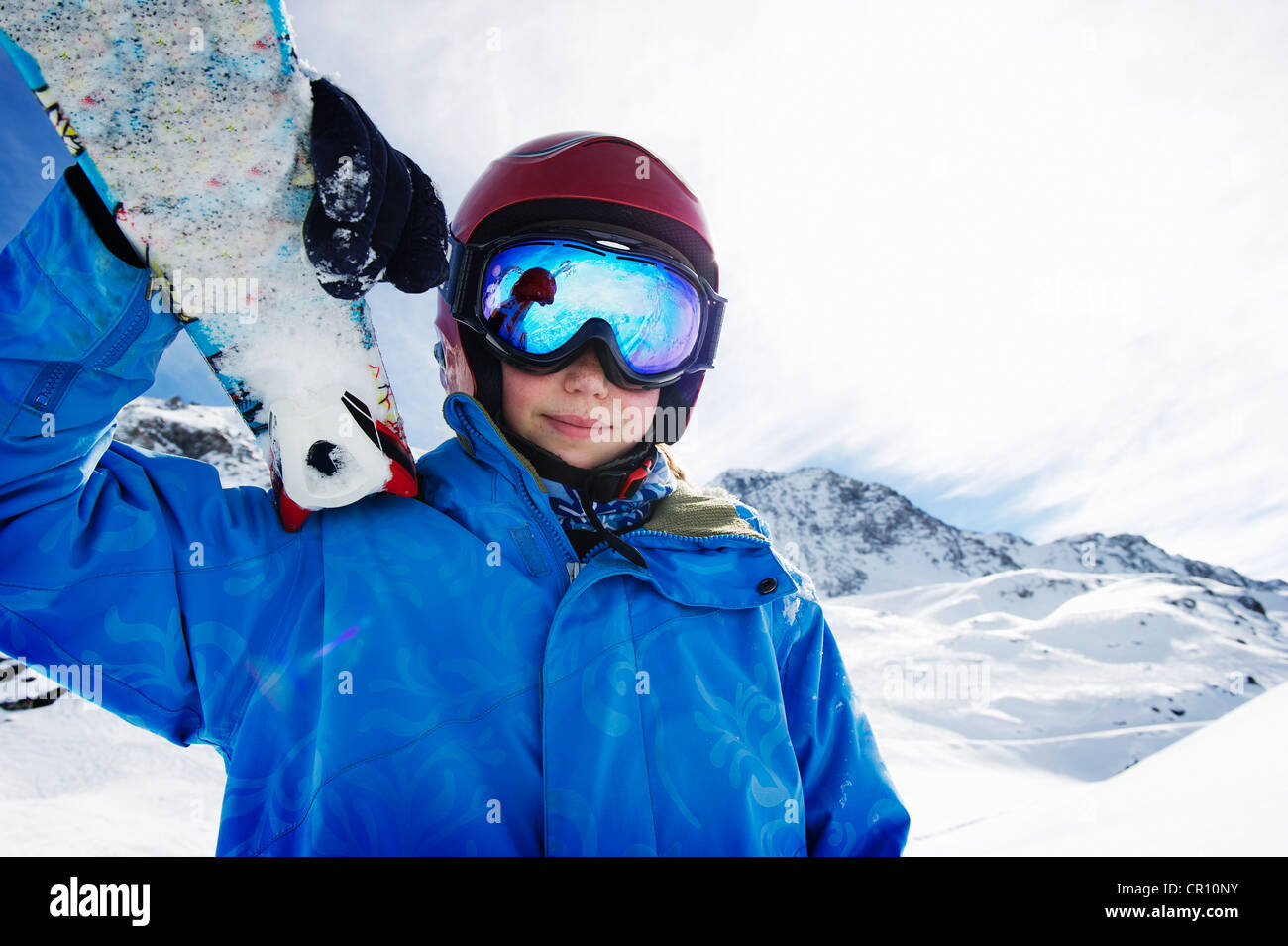 Ragazzo tenendo gli sci sulla montagna innevata Foto Stock