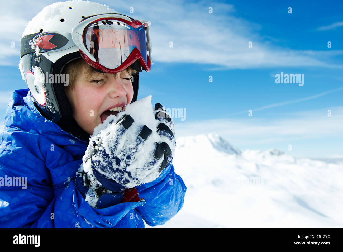 Ragazzo snowball di degustazione in montagna Foto Stock