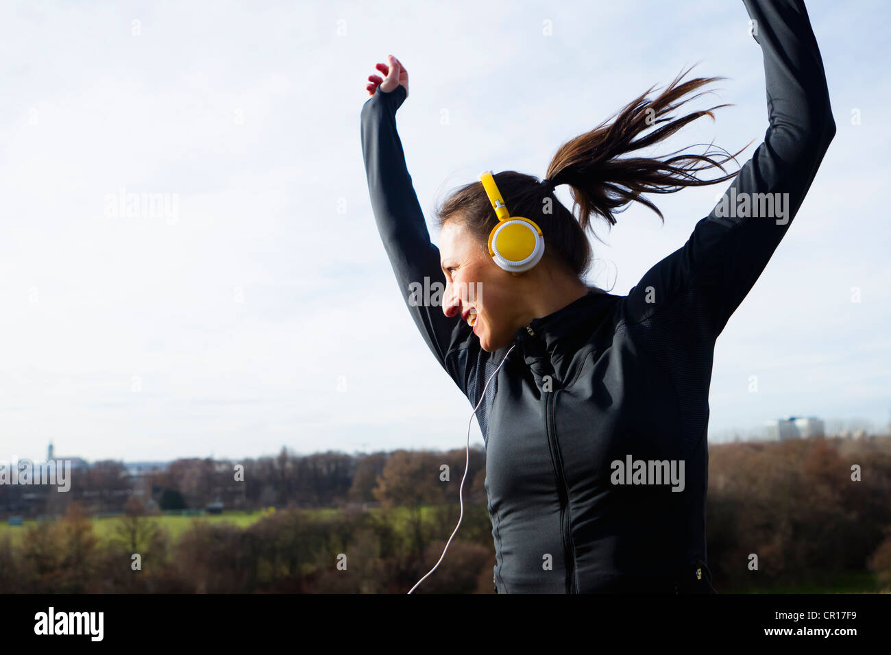 La donna nelle cuffie balli all'aperto Foto Stock