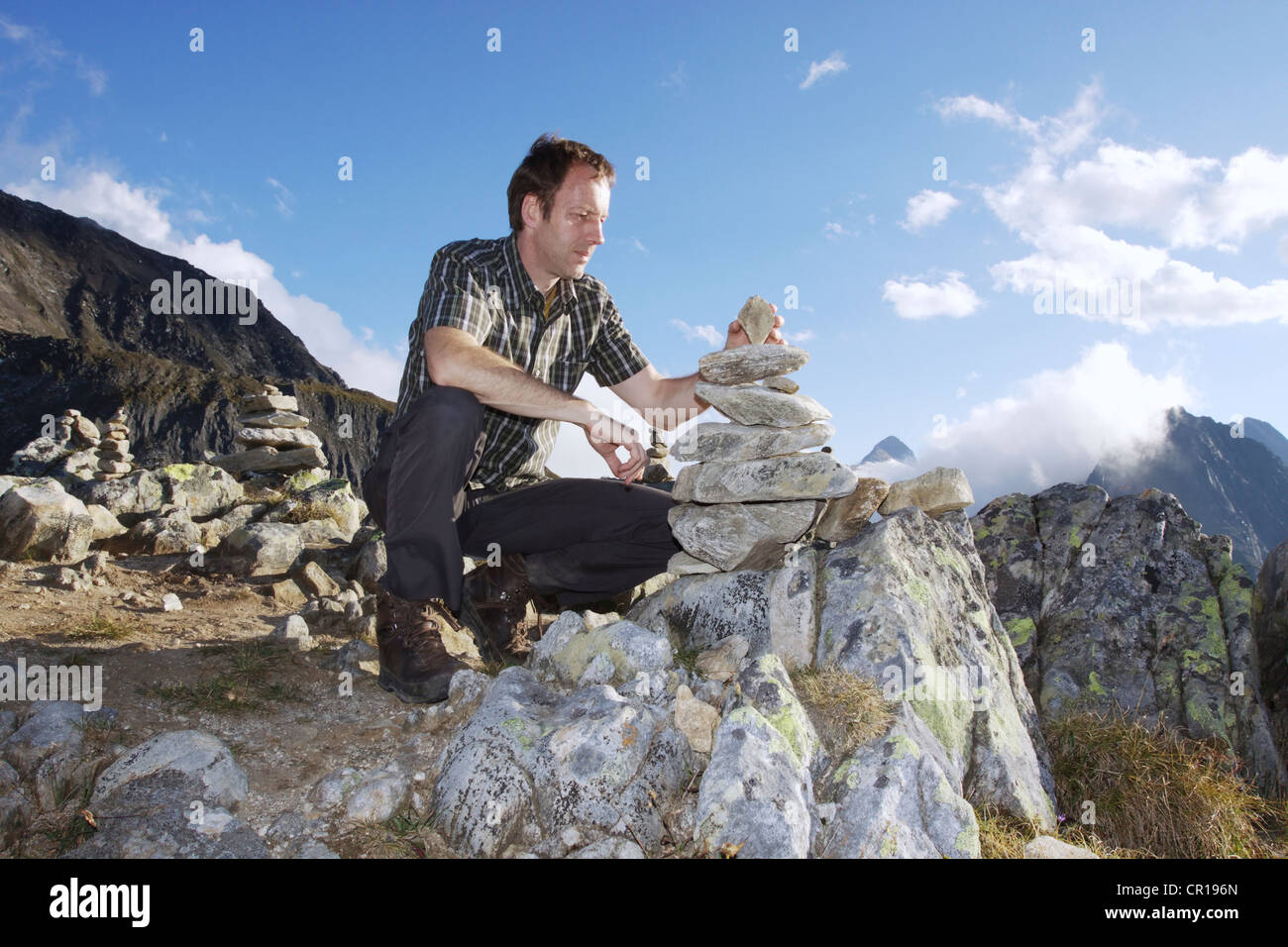 Un escursionista errecting un cairn sul Nufenenpass, 2478 m, Canton Vallese, Svizzera, Europa Foto Stock