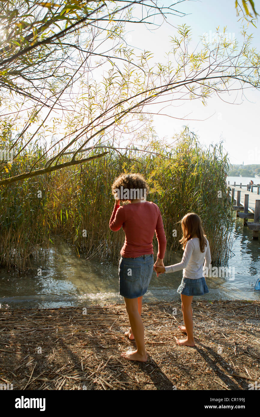 Madre e figlia a piedi dal lago Foto Stock