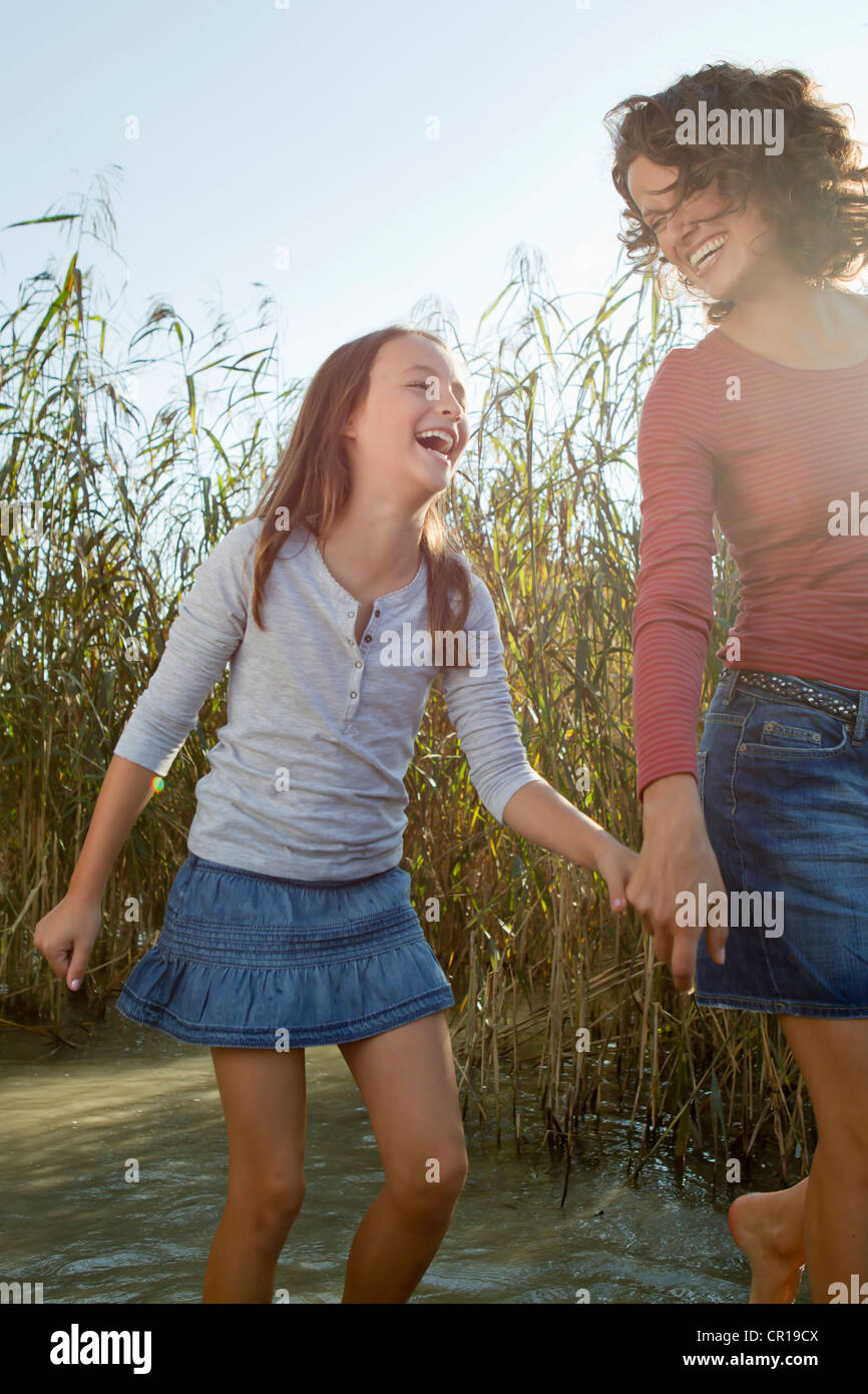 Madre e figlia camminando in stagno Foto Stock