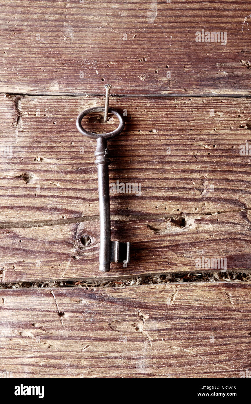 Vecchia chiave appeso su un rustico di parete in legno Foto Stock