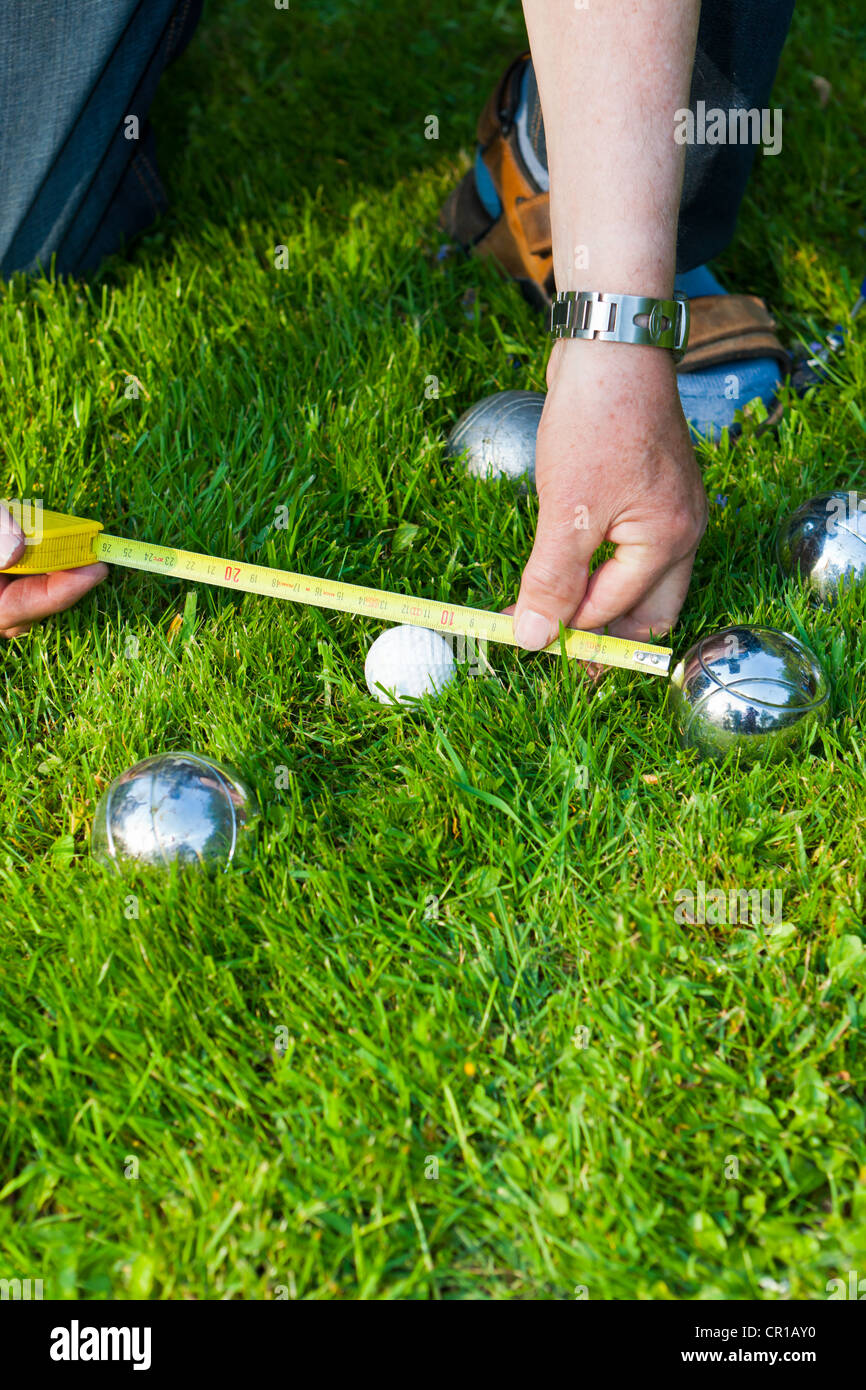 L'uomo giocando a bocce, petanque, misurare le distanze tra le sfere, Hesse, Germania, Europa Foto Stock