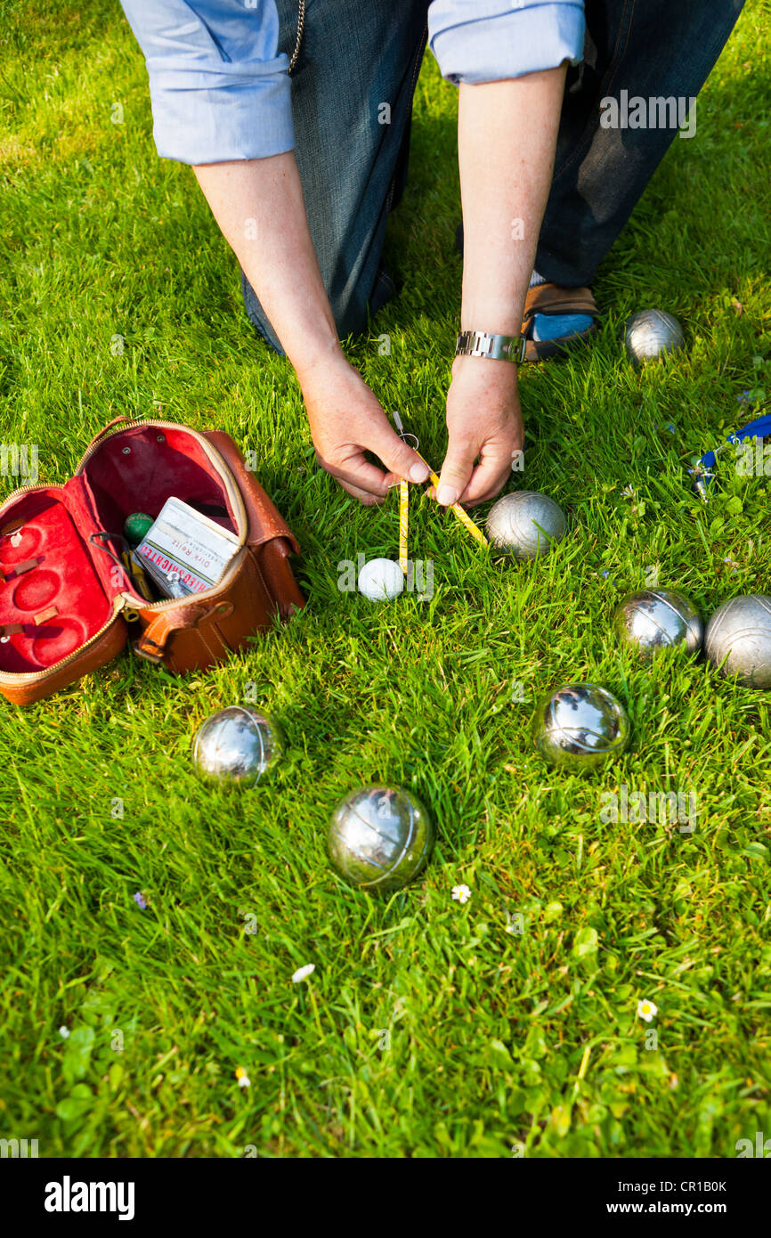 L'uomo giocando a bocce, petanque, misurare le distanze tra le sfere, Hesse, Germania, Europa Foto Stock