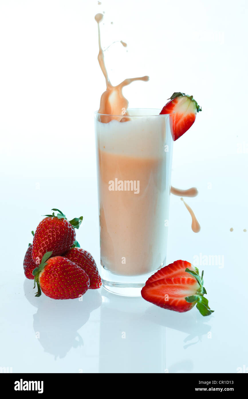 Le fragole rientranti in un yogurt da bere o frullato di fragole in un bicchiere Foto Stock