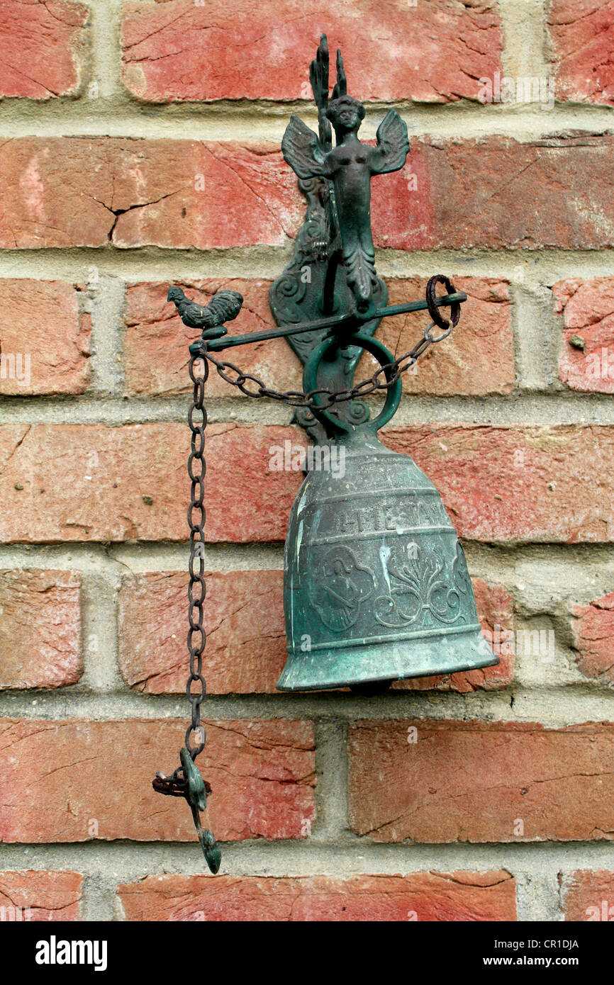 Il vecchio stile porta in ferro campana da un muro di mattoni Foto Stock