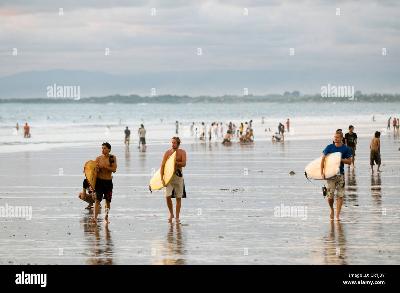 Indonesia, Bali, surfisti al tramonto sulla spiaggia di Kuta. Foto Stock