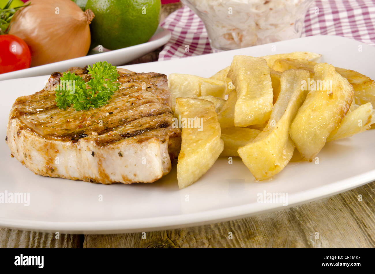 Grigliata di Lombata di manzo con patate fritte su una piastra Foto Stock