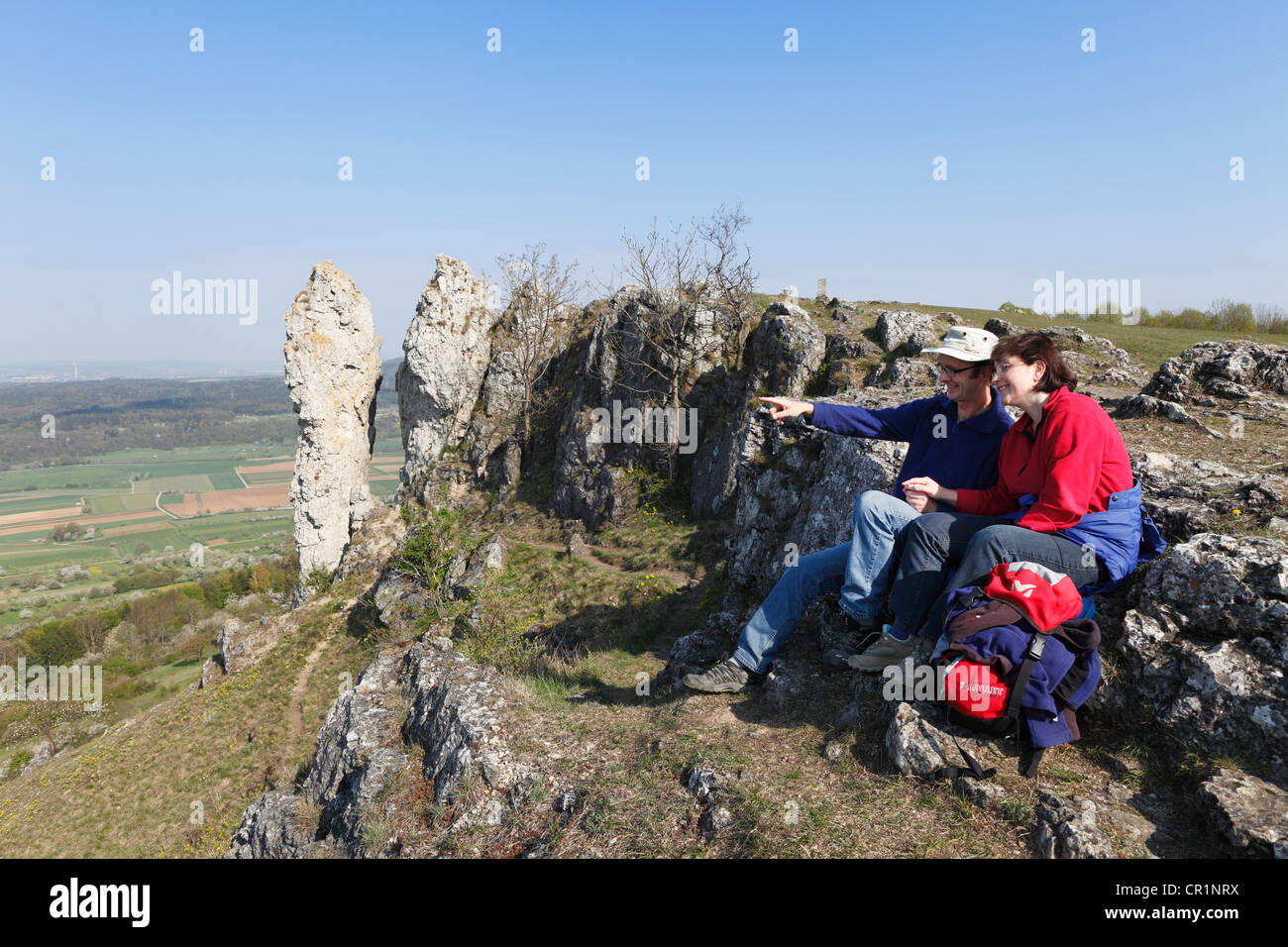 Giovane con zaino seduti sulle rocce, Walberla, Svizzera della Franconia, Alta Franconia, Franconia, Baviera, Germania, Europa Foto Stock