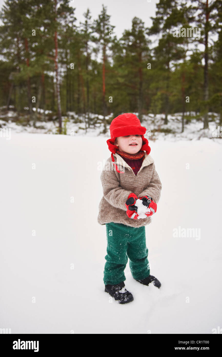 Ragazzo giocare nella neve all'aperto Foto Stock