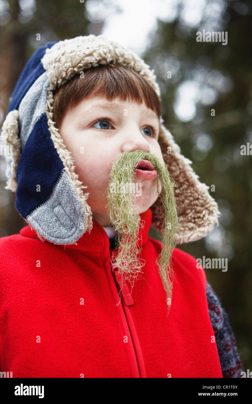 Ragazzo giocando con moss all'aperto Foto Stock