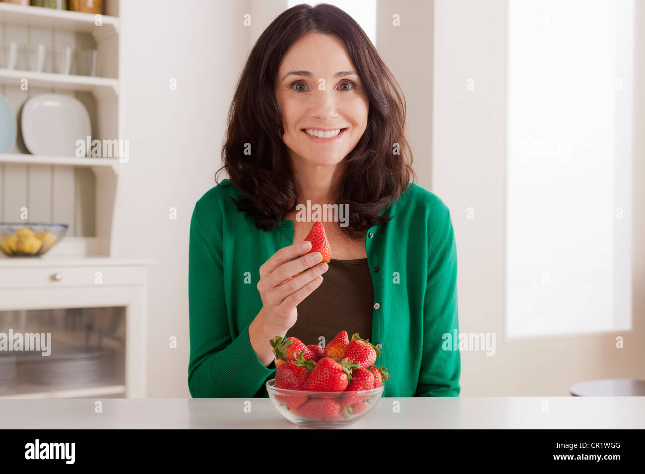 Stati Uniti, California, Los Angeles, ritratto di donna matura con fragole su tavola Foto Stock