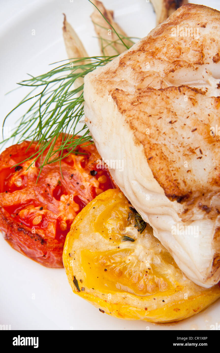 Halibut alla griglia con organici arrosto di rosso e di giallo pomodori e aneto fresco Foto Stock