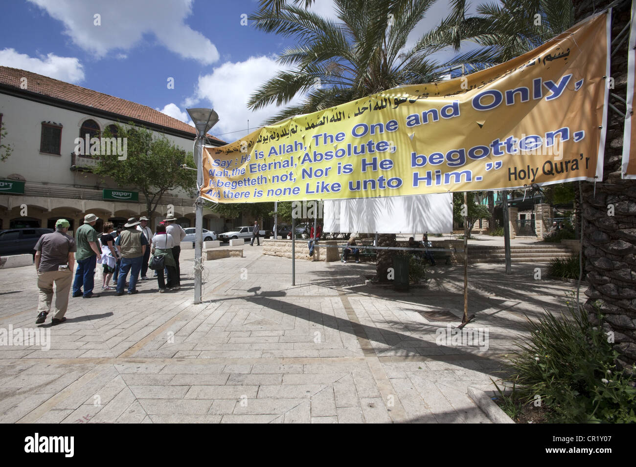 Turisti e un banner con una citazione da il Santo Corano vicino alla chiesa dell'Annunciazione a Nazaret, Israele Foto Stock