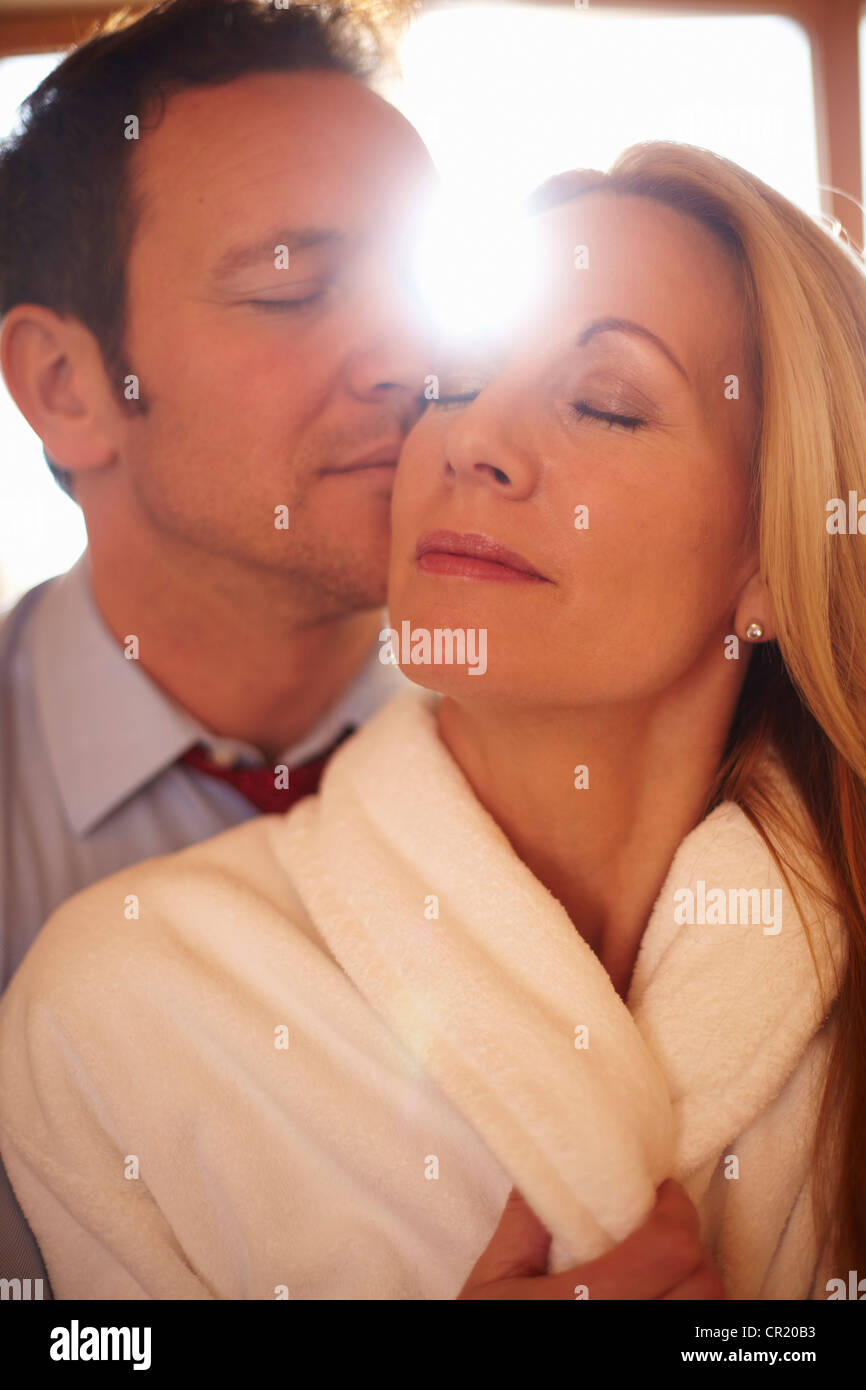 L'uomo baciando la fidanzata in ambienti interni Foto Stock