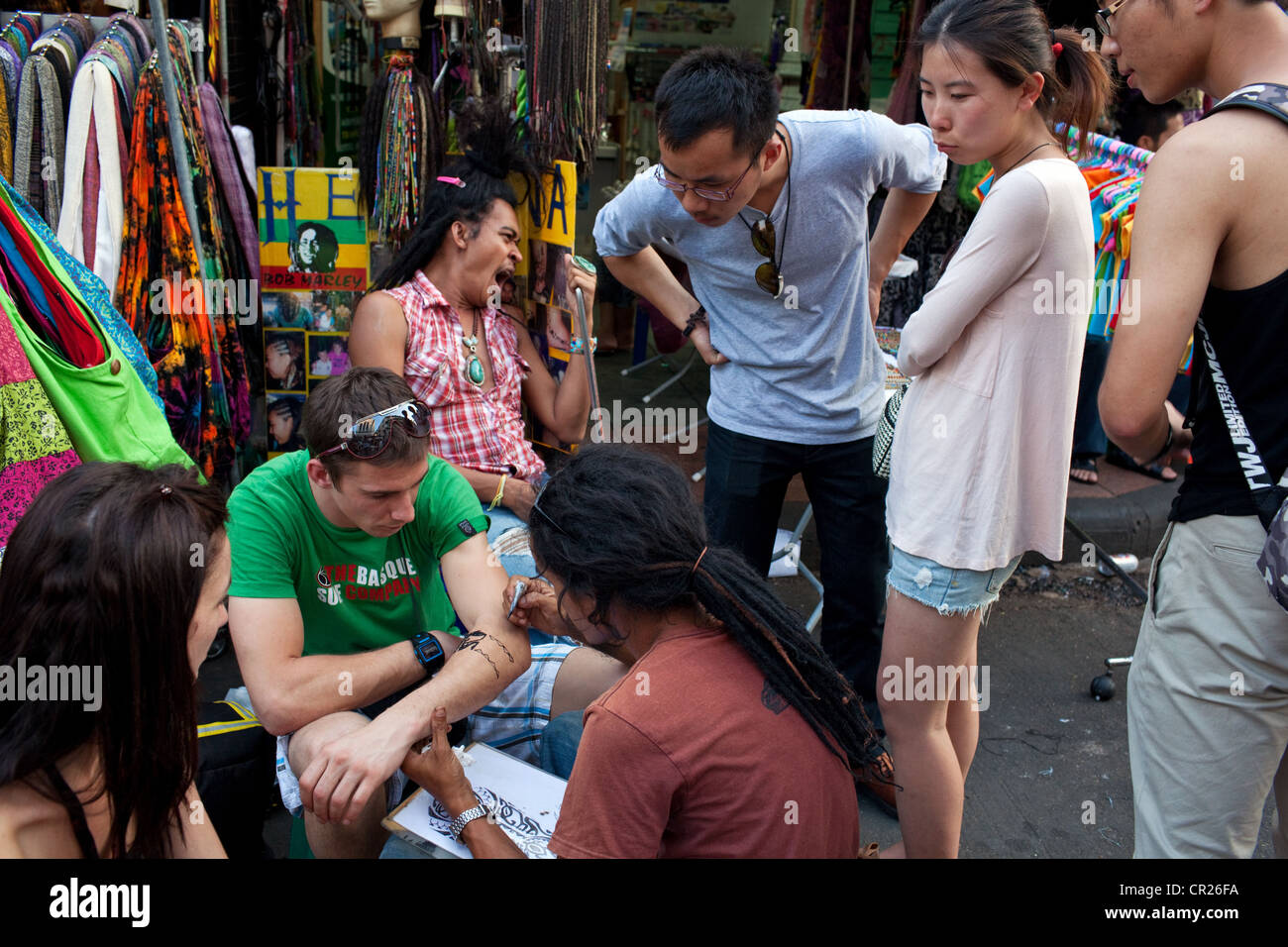 Un turista straniero ottiene un tatuaggio sul Khao San Road di Bangkok, Tailandia. Foto Stock