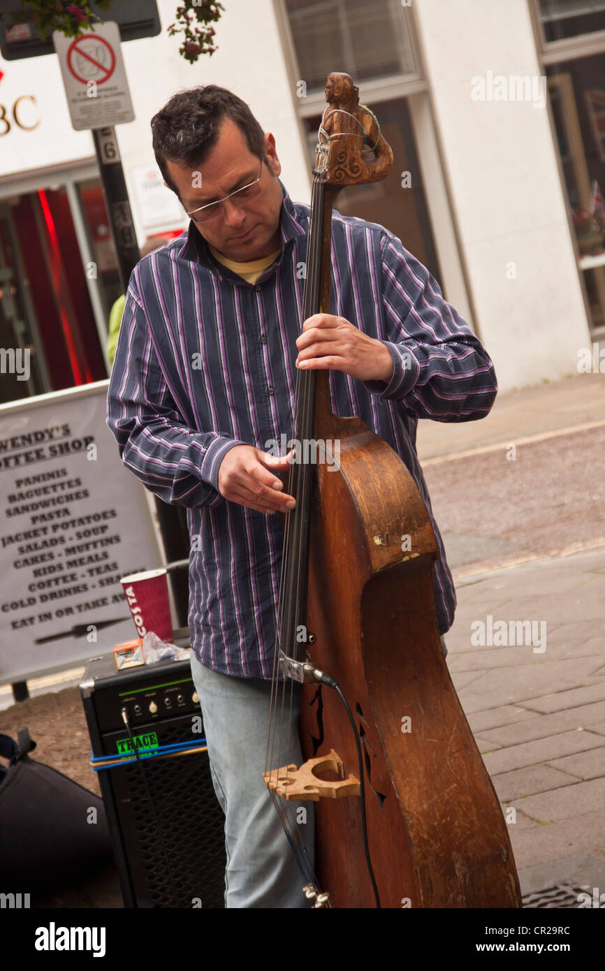 3 pezzo band, gli artisti di strada busker il musicista di strada per le strade di Newton Abbot, Devon, Regno Unito. Foto Stock