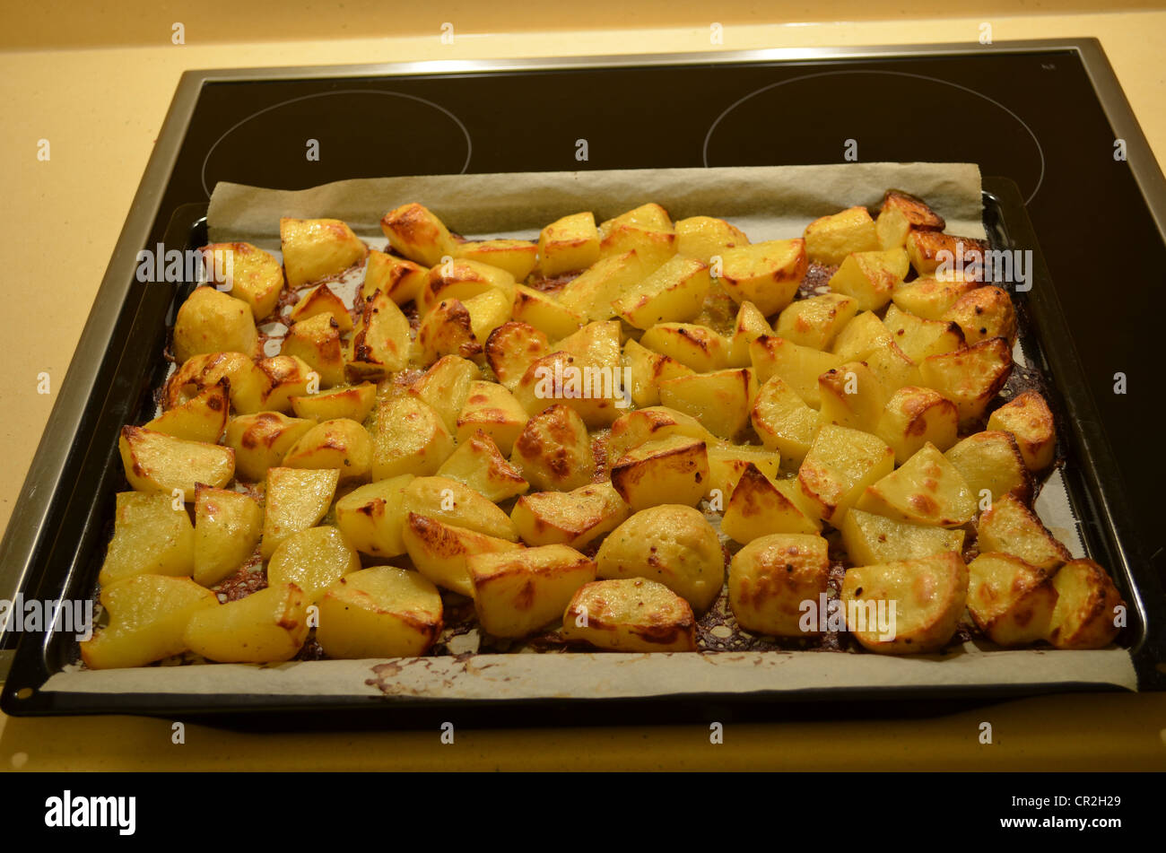 Pane appena sfornato patate su carta da forno in forno vassoio. Un sano cibo a buon mercato dalle verdure. Foto Stock