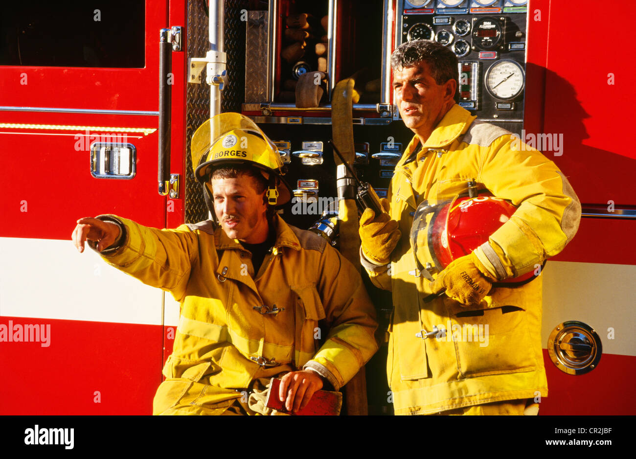 I vigili del fuoco in scambi di parlare alla radio a firetruck Foto Stock