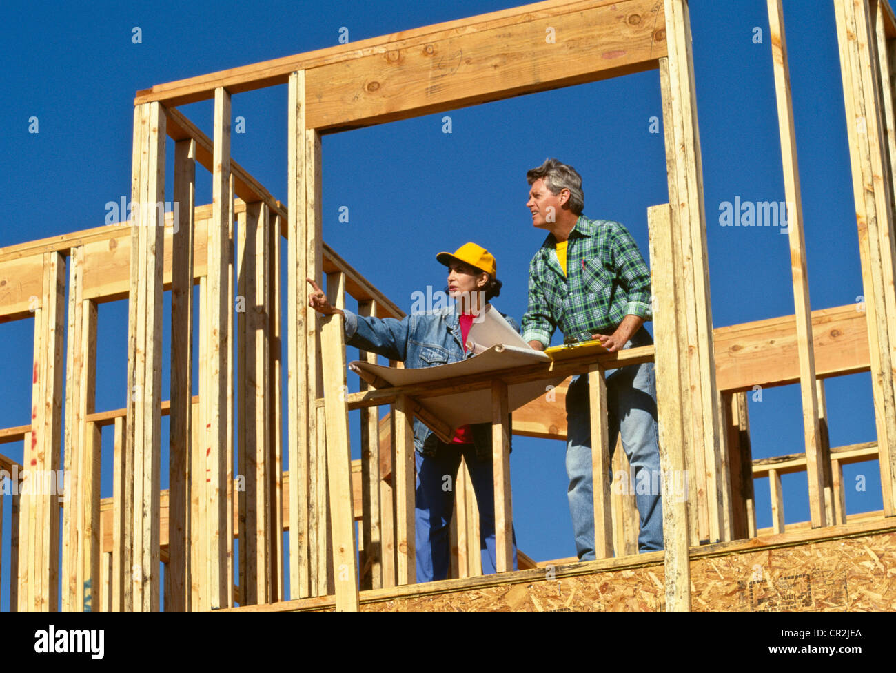 Il capo femmina punta al lavoratore maschio (tradesman,) nel cantiere Foto Stock