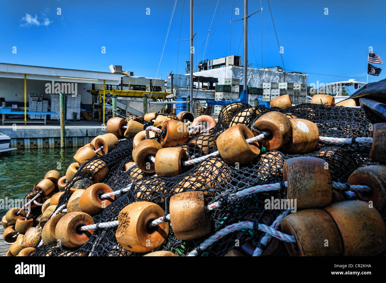 Pila di commerciale delle reti da pesca con galleggianti di fronte un pesce della Florida impianto di lavorazione Foto Stock